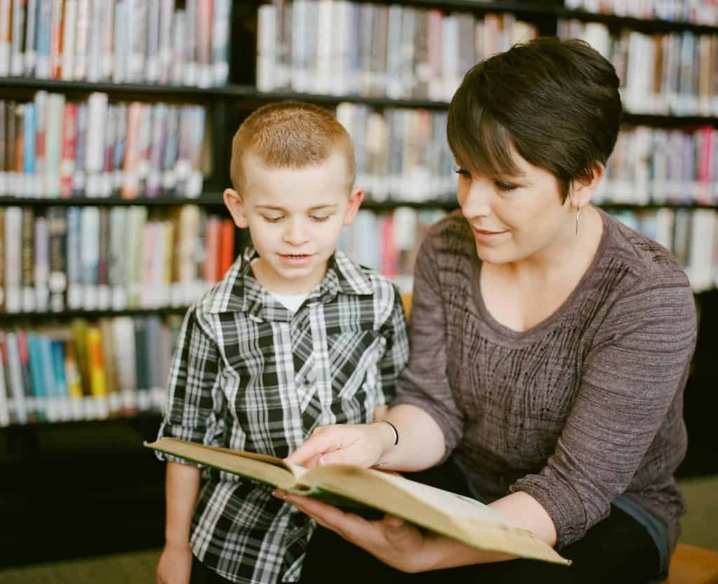 Two young people talking, one explaining something to the other, as a metaphor for teaching and leading