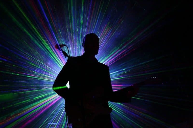 Silhouette with laser lights behind it